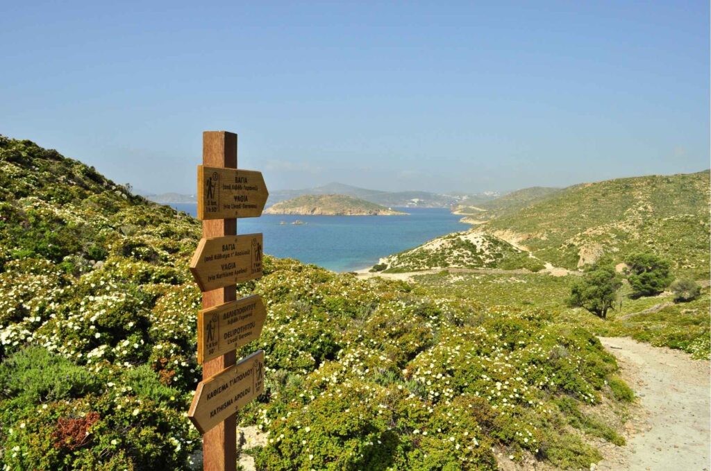 Official Trail Signage in Patmos Wooden directional trail signs pointing along a coastal path in Patmos - Hike Greece